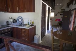 keuken met keukentafel en aan het eind van de kamer stookplaats rechts en tweepersoonsbed links.